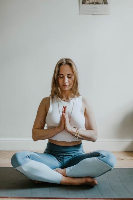 Femme pratiquant la respiration diaphragmatique en position de yoga en intérieur